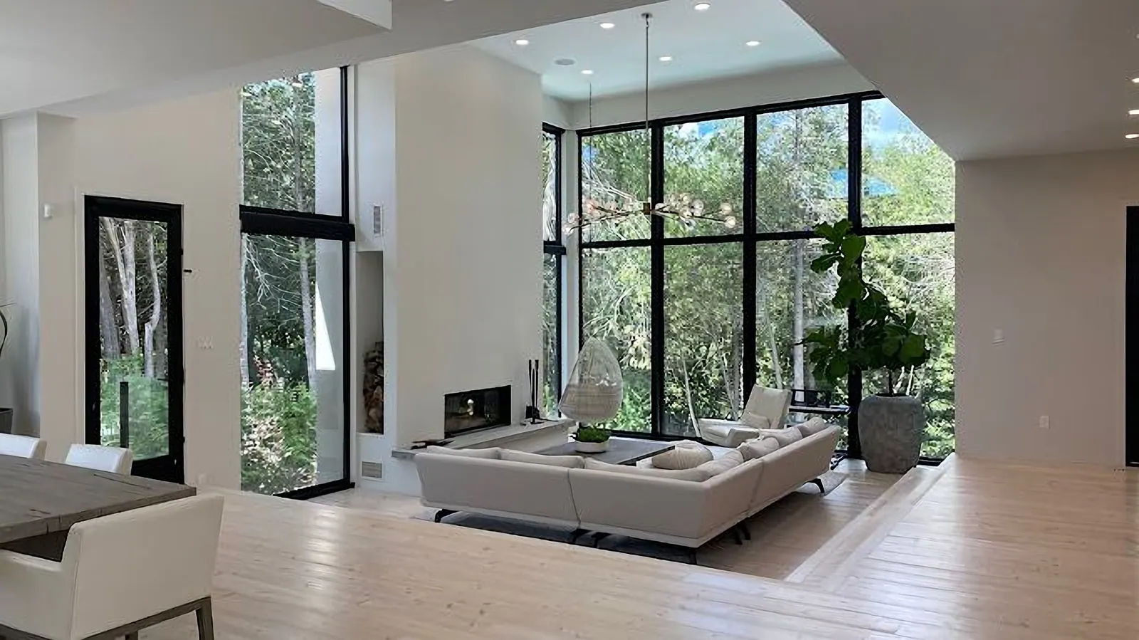 Bright living room with a two-storey wall of windows, freshly painted white walls