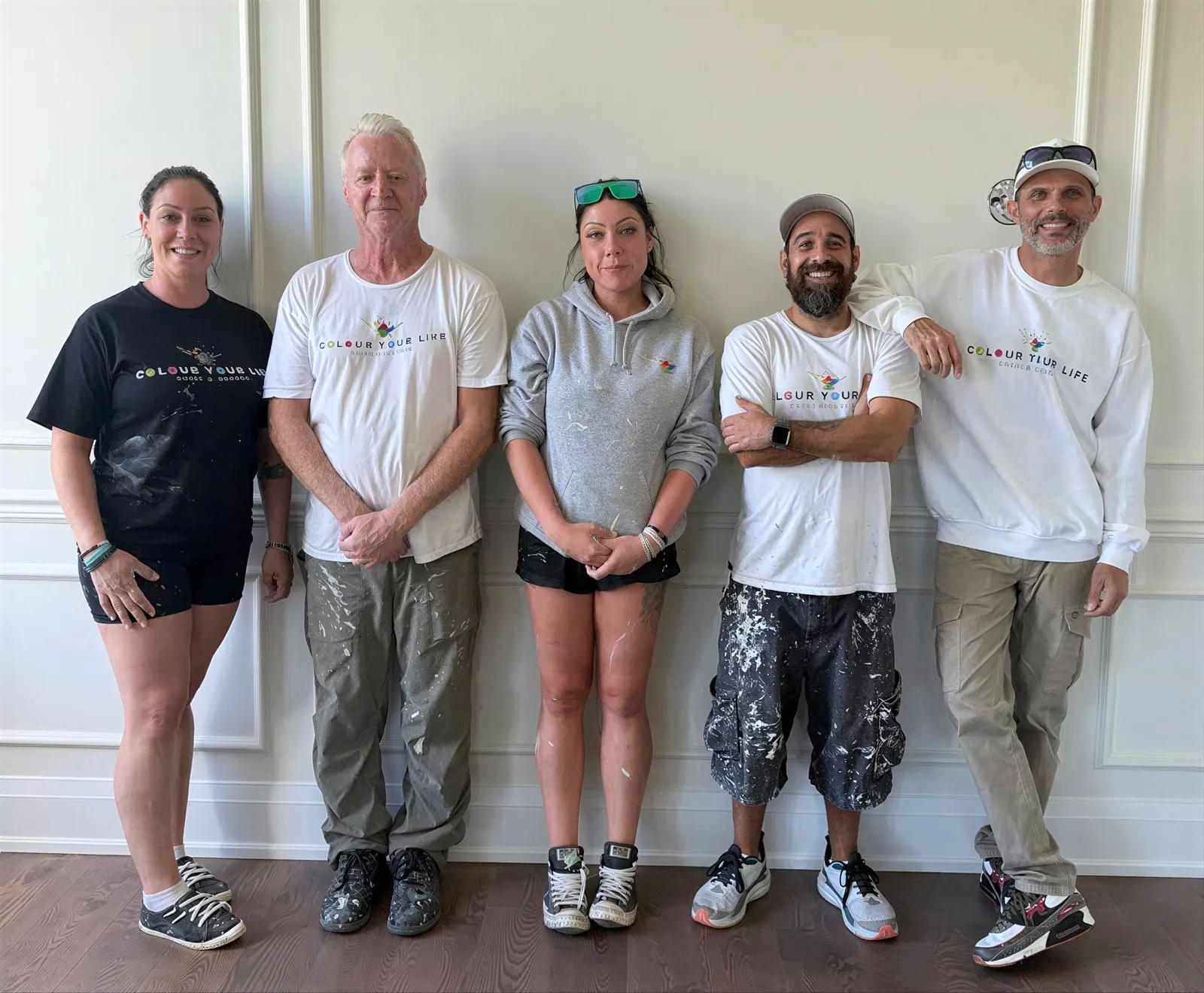 The Colour Your Life painting team standing together in a freshly painted hallway